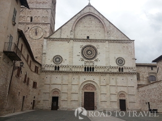 St Rufino Cathedral The San Rufino Cathedral, or Duomo of Assisi, was built in the eighth century, then rebuilt around the year one<br/> thousand. The Cathedral is in the Romanesque style of Umbria, austere, with three rose windows and three <br/>doorways. Inside the baptismal font, which is said to be one in which they were baptized St. Francis, St. Clare and Frederick II of Swabia.