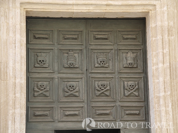 Matera - Cathedral Skull and crossbone carvings on the door of the cathedral.